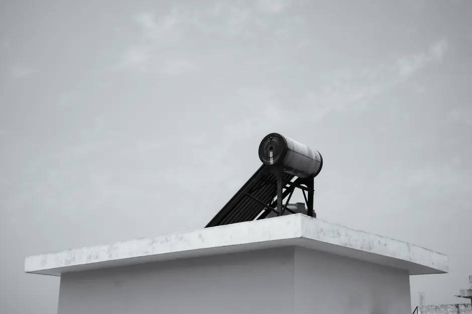 Solar water heater on a rooftop against a clear sky, energy efficient design.